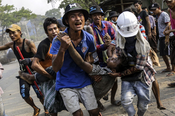 미얀마 군경이 쿠데타에 항의하는 시위대에 대해 연일 유혈진압하는 가운데 14일(현지시간) 최대 도시 양곤 외곽에 있는 흘링타야 시위 현장에서 시위대가 부상당한 시위자를 병원으로 옮기고 있다. 양곤 EPA 연합뉴스