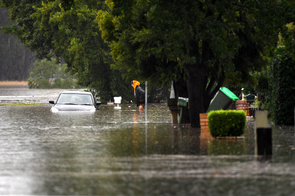 최근 며칠 동안 호주 동남부 연안에 내린 기록적 폭우로 22일(현지시간) 뉴사우스웨일스(NSW)주 피트 타운과 윈저 인근 올드 혹스베리 거리에 차량이 물에 잠겨 있다. EPA 연합뉴스