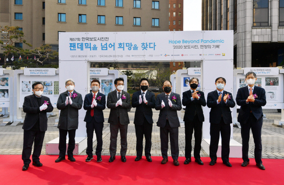 22일 서울 중구 한국프레스센터 광장 전시장에서 열린 ‘팬데믹을 넘어, 희망을 찾다’ 제57회 한국보도사진전 개막식에서 안주영 한국사진기자협회 회장을 비롯한 수상자와 내외빈이 기념촬영을 하고 있다.  사진은 왼쪽부터 조명동 한국보도사진가협회 회장, 이영섭 뉴스1 편집국장, 이백규 뉴스1 대표, 김동훈 한국기자협회 회장, 김기태 뉴스1 기자, 안주영 한국사진기자협회 회장, 김성재 한국언론진흥재단 미디어본부장, 박홍기 한국신문방송편집인협회 회장, 고광현 서울신문 대표.2021. 3. 22 박윤슬 기자 seul@seoul.co.kr