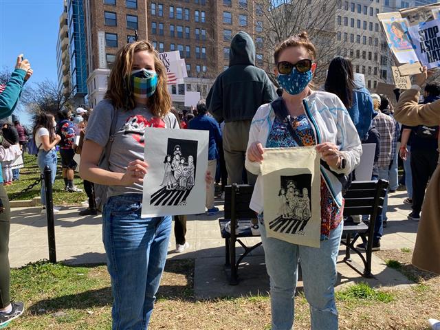 미국 워싱턴DC 맥퍼슨 스퀘어에서 21일(현지시간) 열린 ‘아시아계 미국인 혐오범죄’를 규탄하는 집회에 참석한 어맨다와 멜리사가 얼굴 없는 희생자를 상징하는 판화를 들고 있다.