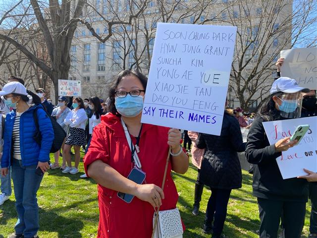 미국 워싱턴DC 맥퍼슨 스퀘어에서 21일(현지시간) 열린 ‘아시아계 미국인 혐오범죄’를 규탄하는 집회에 참석한 중국계 미국인 탄잉이 피해자들의 이름을 적은 피켓을 들고 있다.