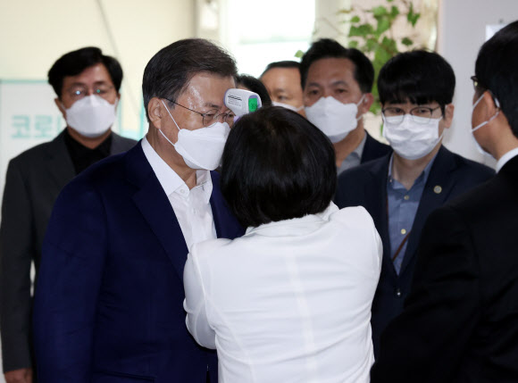 문재인 대통령과 부인 김정숙 여사가 23일 오전 아스트라제네카(AZ)사의 신종 코로나바이러스 감염증(코로나19) 백신 접종을 하기 위해 서울 종로구보건소로 들어서며 발열검사를 받고 있다. 2021.3.23  연합뉴스