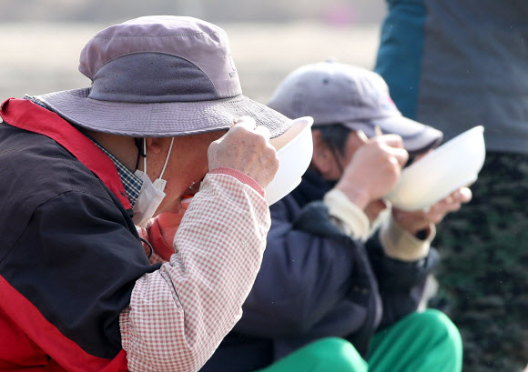 본격적인 영농철이 시작된 23일 오전 강원 춘천시 서면 신매리에서 봄 감자를 심던 농민들이 참을 먹고 있다. 2021.3.23  연합뉴스