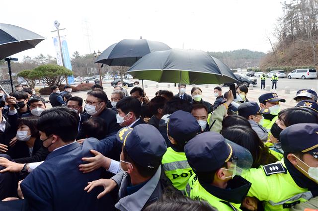 김종인 국민의힘 비상대책위원장이 24일 오전 광주 북구 국립5·18민주묘지를 찾아 묘역으로 이동하던 도중 광주전남 대학생 진보연합 관계자들이 ‘양심의 가책은 느끼냐’고 항의하면서 경찰과 충돌을 빚고 있다. 2021.3.24 뉴스1