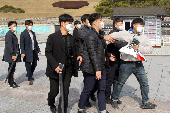24일 오전 국립 5·18 민주묘지에서 국민의힘 김종인 비상대책위원장의 참배에 대학생이 항의하려다 제지당하고 있다. 2021.3.24  연합뉴스