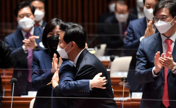 국민의힘 오세훈 서울시장 후보(오른쪽)와 국민의당 안철수 대표가 24일 서울 여의도 국회에서 열린 국민의힘 의원총회에 참석, 포옹하고 있다. 안철수 대표는 국민의힘에서 서울시장 보궐선거 공동선대위원장직을 맡게 됐다. 2021.3.24  연합뉴스