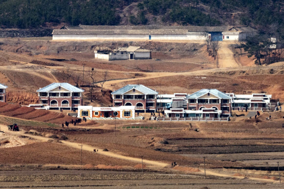 24일 경기도 파주시 오두산 통일전망대에서 바라본 북한 황해북도 개풍군에서 북한 주민들이 모여 이동하고 있다.  북한은 지난해 가을 이곳에서 대규모 재건축 작업을 벌여 새로운 가옥을 조성했다. 2021.3.24  연합뉴스