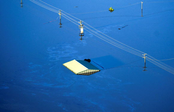 24일(현지시간) 호주 그레이터 시드니 혹스베리 강 인근 윈저 지역과 피트 타운이 홍수로 물에 잠겨 있다. AFP 연합뉴스