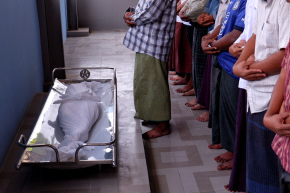 이 사진을 실을지 한참을 고민했으나 미얀마 군부의 잔인무도함을 전달해야 한다는 뜻에서 싣는다. 지난 23일(이하 현지시간) 집안을 뒤지던 경찰의 총질에 숨을 거둔 일곱 살 소녀 킨 묘 칫 장례식이 24일 열린 가운데 무슬림 남성들이 명복을 빌고 있다. 만달레이 로이터 연합뉴스 
