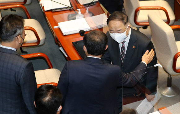 홍남기 경제부총리 겸 기획재정부 장관과 국민의힘 추경호 예산결산특별위원회 야당 간사가  25일 오전 국회 예결위 전체회의에서 4차 재난지원금 지급을 위한 15조원 규모의 추가경정예산안이 통과된 뒤 인사하고 있다. 2021.3.25  연합뉴스