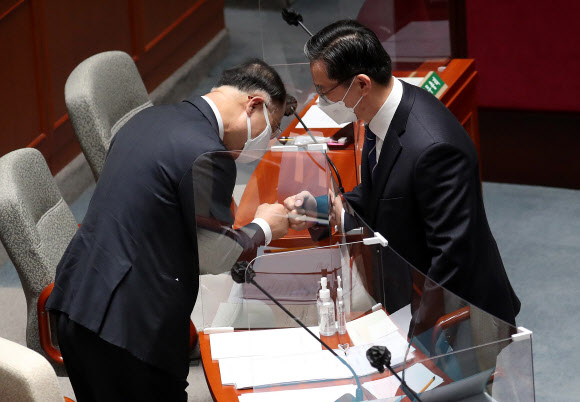 정성호 국회 예산결산특별위원회 위원장(오른쪽)과 홍남기 경제부총리 겸 기획재정부 장관이  25일 오전 국회 예결위 전체회의에서 4차 재난지원금 지급을 위한 15조원 규모의 추가경정예산안이 통과된 뒤 인사하고  있다. 2021.3.25  연합뉴스