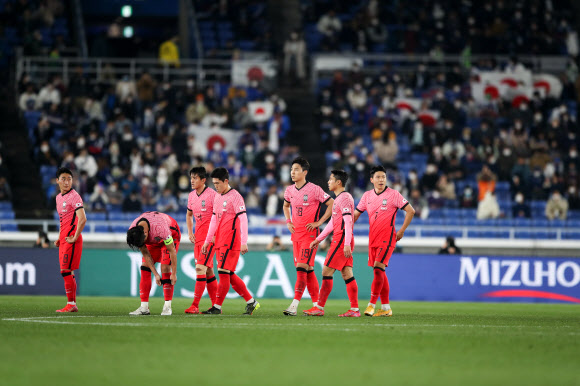 파울루 벤투 감독이 이끄는 축구대표팀 선수들이 25일 일본 요코하마 닛산 스타디움에서 열린 80번째 한일전에서 치욕적인 0-3패를 당한 뒤 고개를 숙인 채 그라운드를 빠져나오고 있다. 세 골 차 패전은 2011년 8월 삿포로 한일전 이후 10년 만이다. 대한축구협회 제공