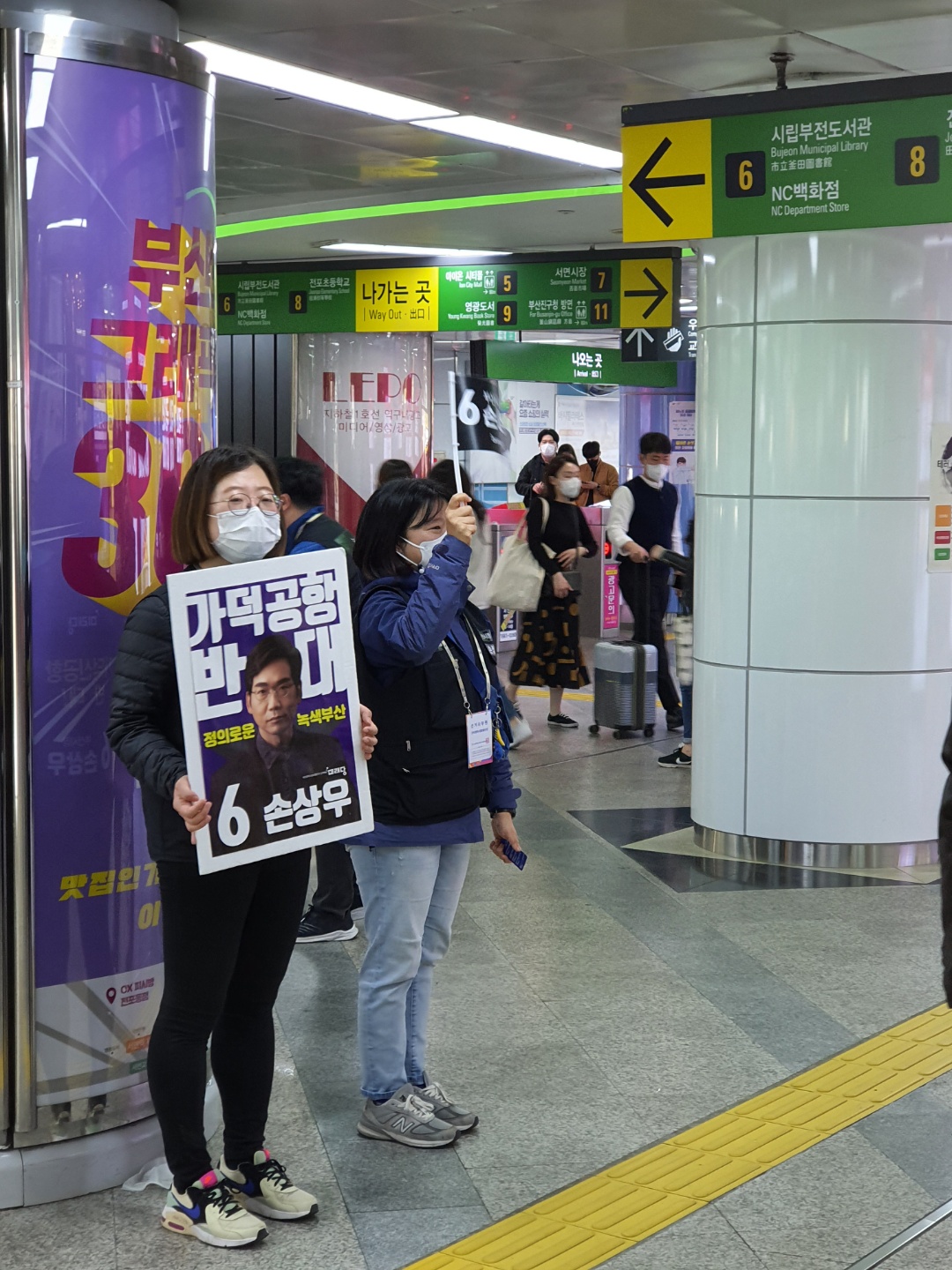 ●27일 오후 서면 지하 상가 입구에서 한 야당 후보 선거운동원들이 ‘가덕공항 반대’ 팻말을 든채 지지를 호소하고 있다. 