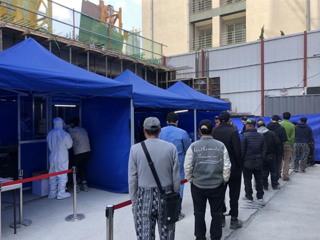 서울 양천구의 한 공사현장에 설치된 ‘찾아가는 선별진료소’에서 외국인노동자들이 코로나19 선제검사를 받기 위해 줄을 서 있다. 양천구 제공