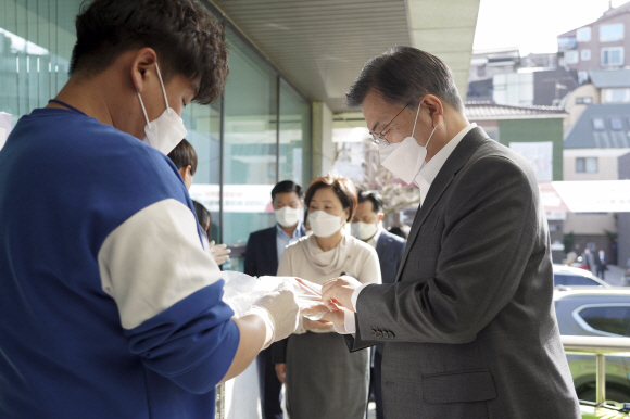 문재인 대통령과 부인 김정숙 여사가 2일 오전 서울 종로구 삼청동 주민센터를 방문해 2021재?보궐선거 사전투표 했다. 문 대통령이 투표소에 들어가기 전 비닐 장갑을 끼고 있다. 2021. 4. 2 청와대사진기자단