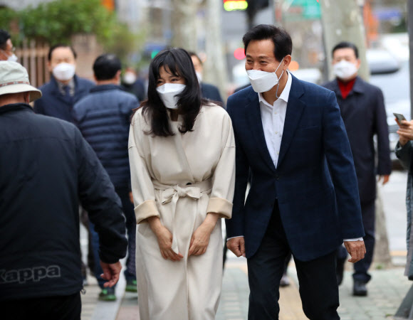 국민의힘 오세훈 서울시장 후보와 부인 송현옥 씨가 3일 서울 광진구 자양3동 주민센터 사전투표소로 향하던 중 시민들에게 인사하고 있다.  2021.4.3  연합뉴스