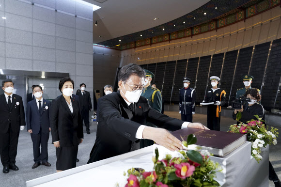 문재인 대통령이 3일 오전 제주 4·3 평화공원 내 위패봉안실에서 참배를 마치고 제주 4·3 특별법 개정안 책자에 서명 후 거치단에 봉헌하고 있다. 2021.4.3  연합뉴스