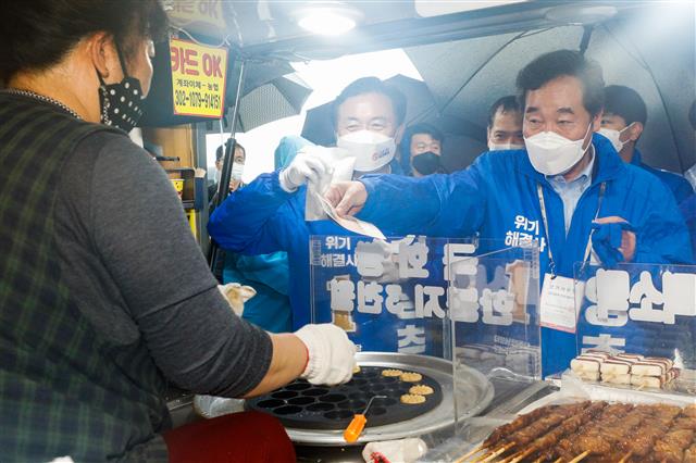 이낙연 더불어민주당 상임선거대책위원장이 사전투표 마지막 날인 3일 오후 부산 해운대구 반여농수산물시장 앞에서 김영춘 부산시장 후보 유세를 마친 뒤 국화빵을 구입하고 있다. 2021.4.3 뉴스1