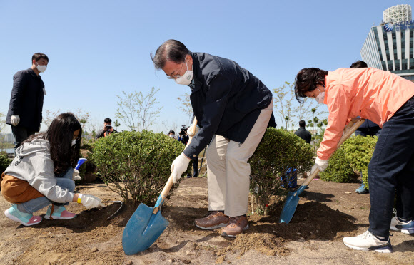 문재인 대통령과 김정숙 여사가 5일 마포구 서울복합화력발전소에서 열린 제76회 식목일 기념행사에서 학생들과 나무를 심고 있다. 2021.4.5  연합뉴스