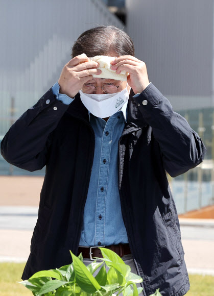 문재인 대통령이 5일 마포구 서울복합화력발전소에서 열린 제76회 식목일 기념행사에서 식수를 마치고 환담 장소로 이동해 이마의 땀을 닦고 있다. 2021.4.5  연합뉴스