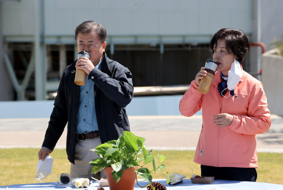 문재인 대통령과 김정숙 여사가 5일 마포구 서울복합화력발전소에서 열린 제76회 식목일 기념행사에서 식수 후 환담하며 물푸레, 백합나무로 제작된 텀블러로 오미자 에이드를 마시고 있다. 2021.4.5  연합뉴스