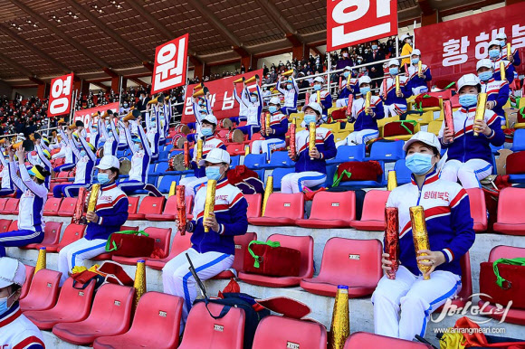 북한이 김일성 주석 생일(‘태양절’4월 15일)을 앞두고 평양에서 태양절 경축 전국 도대항 군중 체육대회-2021을 열었다고 대외선전매체 메아리가 6일 보도했다. 마스크를 한 응원단이 좌석 간 거리를 두고 앉아 응원하고 있다. 2021.4.6  메아리 홈페이지 캡처