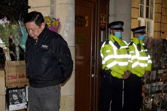 7일(현지시간) 영국 런던 주재 미얀마대사관 건물이 봉쇄된 가운데 무관에 의해 입장을 거부당한 쪼 츠와 민 대사가 밤거리를 배회하고 있다. 그는 대사관에 들어가야 한다며 일종의 시위를 하고 있다. 런던 AFP 연합뉴스 