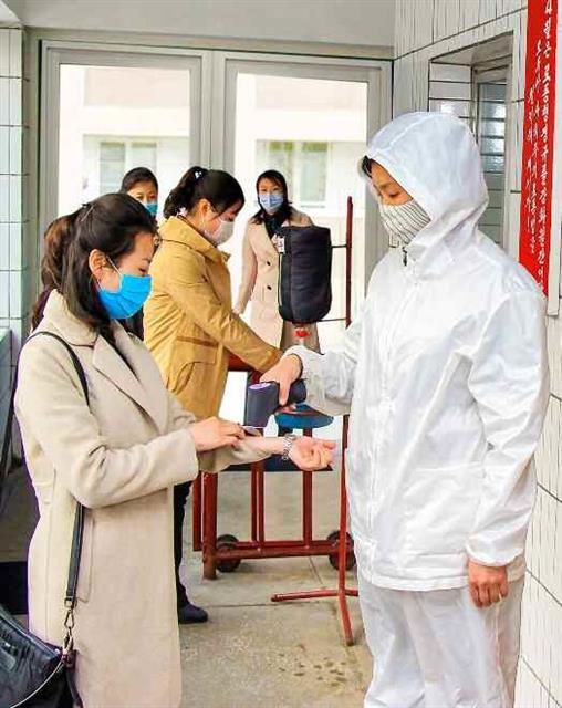 북한 노동당 기관지 노동신문은 8일 신종 코로나바이러스 감염증(코로나19) 비상방역 사업의 완벽성을 보장하라고 촉구했다. 사진은 문수봉화피복공장에서 체온 측정을 하는 모습. 평양 노동신문 뉴스1