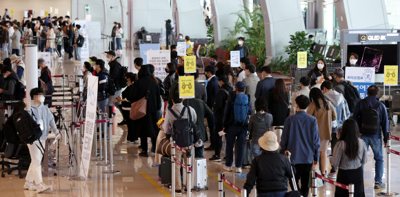 11일 오전 서울 김포공항 탑승장이 탑승객들로 붐비고 있다. 중앙방역대책본부에 따르면 이날 0시 기준 코로나19 신규 확진자 수는 614명으로 사흘 연속 600명대를 이어갔다.  한편 코로나19 확산을 막기 위한 거리두기 단계는 12일부터 다음 달 2일까지 3주 동안 현행 단계를 유지하되 유흥주점업, 단란주점, 홀덤펍 등 6개 업종에 대해서는 사실상 영업금지에 해당하는 집합 금지 조치가 취해진다. 2021.4.11  연합뉴스