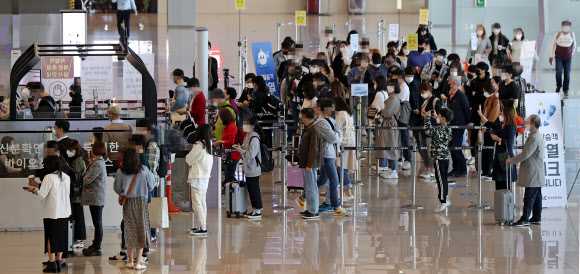 11일 오전 서울 김포공항 탑승장이 탑승객들로 붐비고 있다. 중앙방역대책본부에 따르면 이날 0시 기준 코로나19 신규 확진자 수는 614명으로 사흘 연속 600명대를 이어갔다.  한편 코로나19 확산을 막기 위한 거리두기 단계는 12일부터 다음 달 2일까지 3주 동안 현행 단계를 유지하되 유흥주점업, 단란주점, 홀덤펍 등 6개 업종에 대해서는 사실상 영업금지에 해당하는 집합 금지 조치가 취해진다. 2021.4.11  연합뉴스