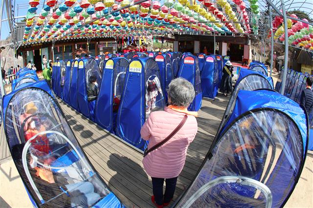 11일 오전 대구 달성군 비슬산 대견사에서 열린 나한상 및 산신탱화 점안법회에 참석한 불교 신자들이 신종 코로나바이러스 감염증(코로나19) 예방을 위해 1인 1실로 마련된 개인 방역 텐트 안에서 기도를 올리고 있다. 2021.4.11 뉴스1