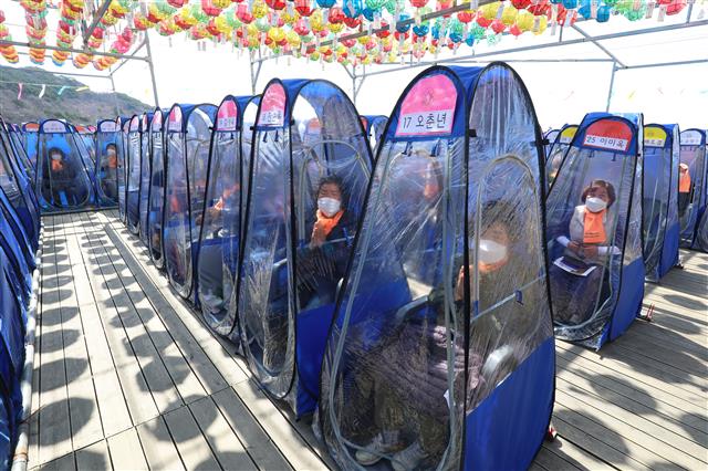 11일 오전 대구 달성군 비슬산 대견사에서 열린 나한상 및 산신탱화 점안법회에 참석한 불교 신자들이 신종 코로나바이러스 감염증(코로나19) 예방을 위해 1인 1실로 마련된 개인 방역 텐트 안에서 기도를 올리고 있다. 2021.4.11 뉴스1