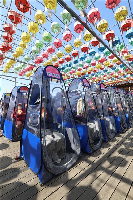 11일 오전 대구 달성군 비슬산 대견사에서 열린 나한상 및 산신탱화 점안법회에 참석한 불교 신자들이 신종 코로나바이러스 감염증(코로나19) 예방을 위해 1인 1실로 마련된 개인 방역 텐트 안에서 기도를 올리고 있다. 2021.4.11 뉴스1