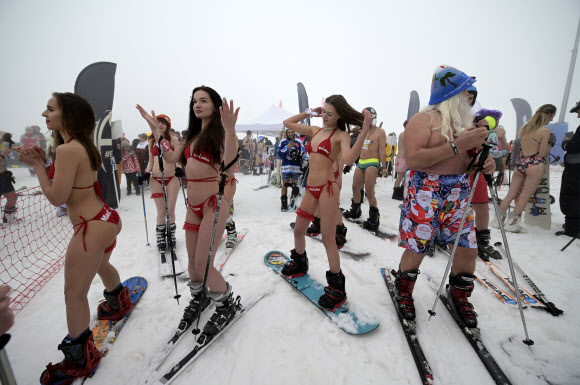 수영복을 입은 여성들이 10일(현지시간) 러시아 흑해 휴양지 소치 인근 크라스나야 폴랴나 리조트에서 열린 ‘부겔우겔 축제’중 ‘수영복 입고 스키·스노보드 타기’에 참가해 포즈를 취하고 있다. AP 연합뉴스