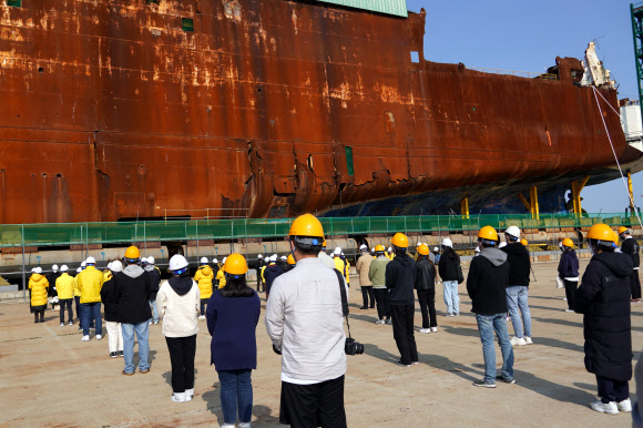 11일 오전 전남 목포시 목포신항에 인양된 세월호 선체 앞에서 세월호 참사 피해 가족들이 헌화와 묵념을 하며 피해자를 추모하고 있다. 피해 가족들은 이날 참사 해역에서 선상 추모식을 하려 했지만 해경이 사고 당시 현장지휘선으로 쓰인 ‘3009함’을 준비하자 탑승을 거부하고 세월호 선체 앞에서 추모식을 열었다. 2021.4.11  4·16 재단 제공