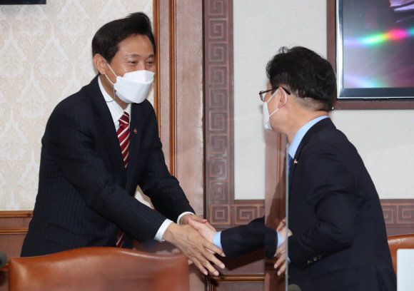 오세훈 서울시장이 13일 서울 종로구 정부서울청사에서 열린 국무회의에 참석하며 박범계 법무부 장관과 악수하고 있다. 2021. 4. 13 박윤슬 기자 seul@seoul.co.kr