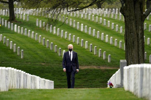 조 바이든 미국 대통령이 14일(현지시간) 버지니아주 알링턴 국립묘지의 제60구역에서 묘비 사이를 걸어가고 있다. 60구역은 2001년 9·11테러 이후 벌인 ‘테러와의 전쟁’으로 순직한 장병들이 묻힌 곳이다. 바이든은 이날 올해 9월 11일까지 아프가니스탄에 주둔하는 미군을 모두 철수시키겠다고 발표했다. 알링턴 AP 연합뉴스