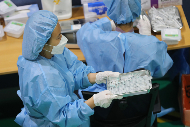 15일 광주 북구 예방접종센터에서 의료진들이 주사기에 옮겨 담은 백신을 조심스럽게 옮기고 있다 (위 기사와 관련 없음). 연합뉴스