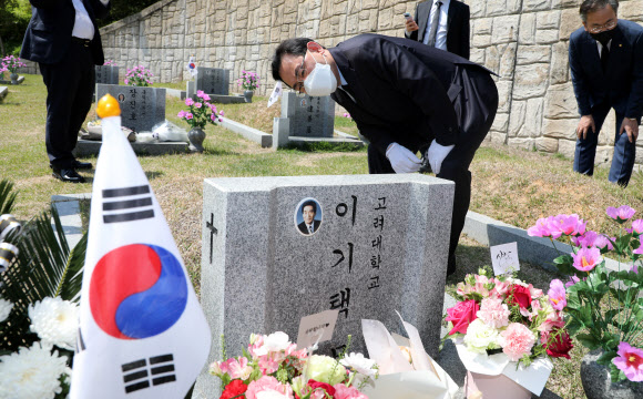 국민의힘 주호영 원내대표 겸 대표 권한대행이 19일 강북구 국립 4·19 민주묘지에서 이기택 전 민주당 총재의 묘비를 살피고 있다. 2021.4.19  연합뉴스