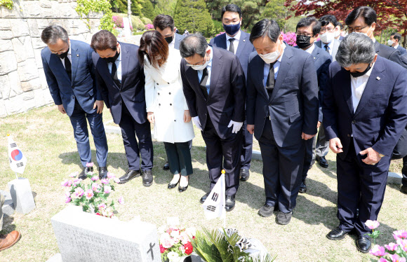 국민의힘 주호영 원내대표 겸 대표 권한대행과 당직자들이 19일 강북구 국립 4·19 민주묘지 이기택 전 민주당 총재의 묘비에서 묵념하고 있다. 2021.4.19  연합뉴스