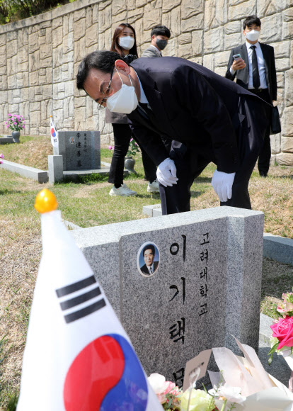 국민의힘 주호영 원내대표 겸 대표 권한대행이 19일 강북구 국립 4·19 민주묘지에서 이기택 전 민주당 총재의 묘비를 살피고 있다. 2021.4.19  연합뉴스