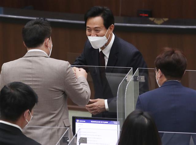 오세훈 서울시장이 19일 오후 서울 중구 서울시의회에서 열린 ‘제300회 시의회 임시회’에서 시의회 의원들과 인사를 나누고 있다. 2021.4.19 뉴스1