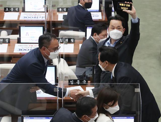 오세훈 서울시장이 19일 오후 서울 중구 서울시의회에서 열린 ‘제300회 시의회 임시회’에서 시의회 의원들과 인사를 하고 있다. 오 시장 뒤의 임종국 더불어민주당 서울시의회 의원이 스마트 폰으로 ‘부동산 상승 기대감?’ 문구를 들어보이고 있다. 2021.4.19 뉴스1