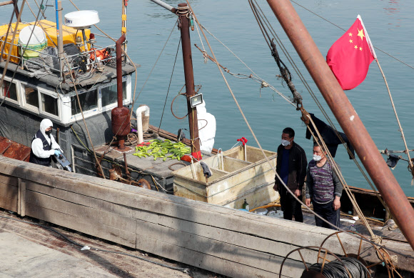 21일 오전 인천시 중구 인천해경 전용부두에서 방역 당국 관계자들이 해경에 나포된 불법조업 중국어선을 소독하고 있다. 이 어선은 전날 인천시 옹진군 소청도 인근 해상에서 불법조업을 하다가 해경에 나포됐다. 2021.4.21  연합뉴스
