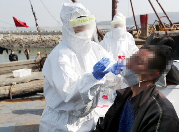 21일 오전 인천시 중구 인천해경 전용부두에서 방역 당국 관계자들이 해경에 붙잡힌 불법조업 중국어선 선원을 상대로 신종 코로나바이러스 감염증(코로나19) 검사를 하고 있다. 2021.4.21  연합뉴스