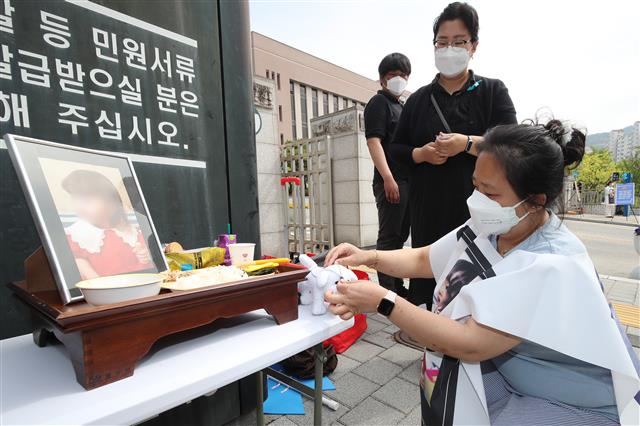 경북 구미에서 방치돼 숨진 3세 여아 친모 A씨(49)의 첫 재판이 열리는 22일 오전 대한아동학대방지협회 회원들이 대구지방법원 김천지원 정문 앞에서 밥과 간식으로 밥상을 차려 놓고 인형을 올려 숨진 여아를 추모하고 있다. 2021.4,22 뉴스1
