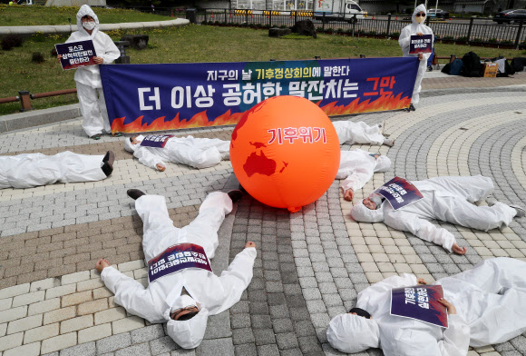 지구의날인 22일 오전 기후위기비상행동이 청와대 분수대 앞에서 뜨거워진 지구에 고통받는 인간을 표현한 퍼포먼스를 하고 있다. 2021.4.22  연합뉴스