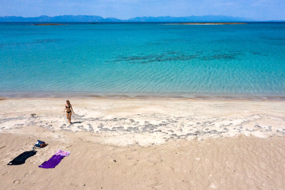 한 여성이 23일(현지시간) 그리스 남부의 작은 섬인 엘라피니소스의 해변에서 바다를 즐기고 있다. AFP 연합뉴스