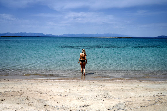 한 여성이 23일(현지시간) 그리스 남부의 작은 섬인 엘라피니소스의 해변에서 바다를 즐기고 있다. AFP 연합뉴스