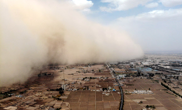 중국 북서부 간쑤성 장예의 린쩌현에서 25일 거대한 모래폭풍이 마을을 덮치고 있다. 이번 모래폭풍은 네이멍구자치구의 사막에서 발원했으며 높이가 무려 100m에 이른다고 현지 언론이 보도했다. 장예 AFP 연합뉴스